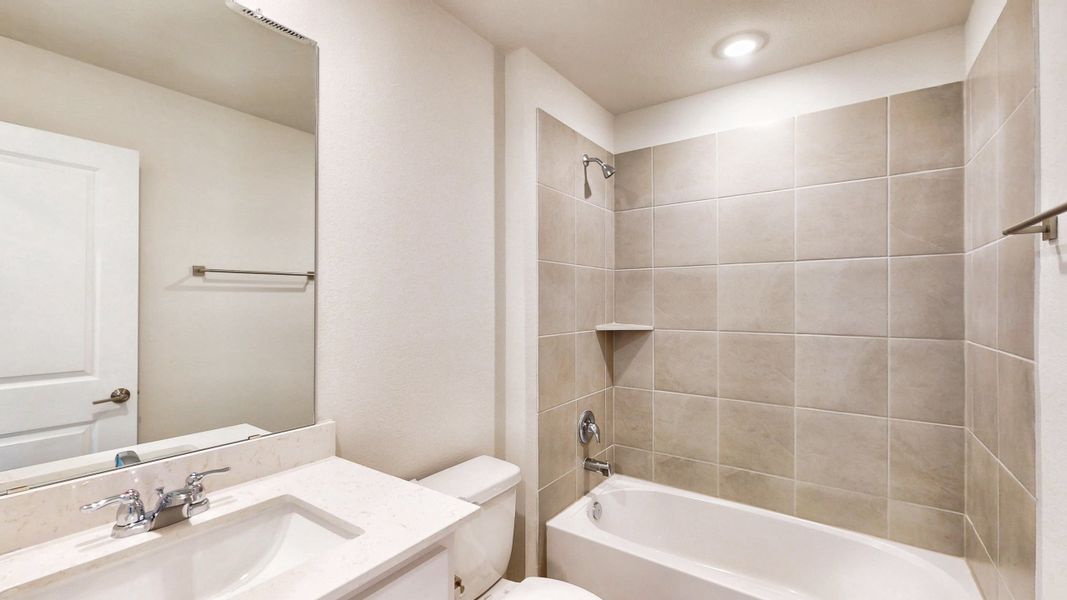 A bathroom with a tub sink and toilet.