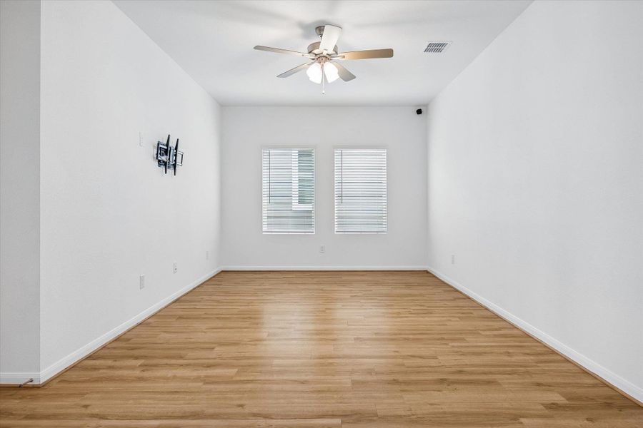Empty room featuring ceiling fan and light wood finished floors
