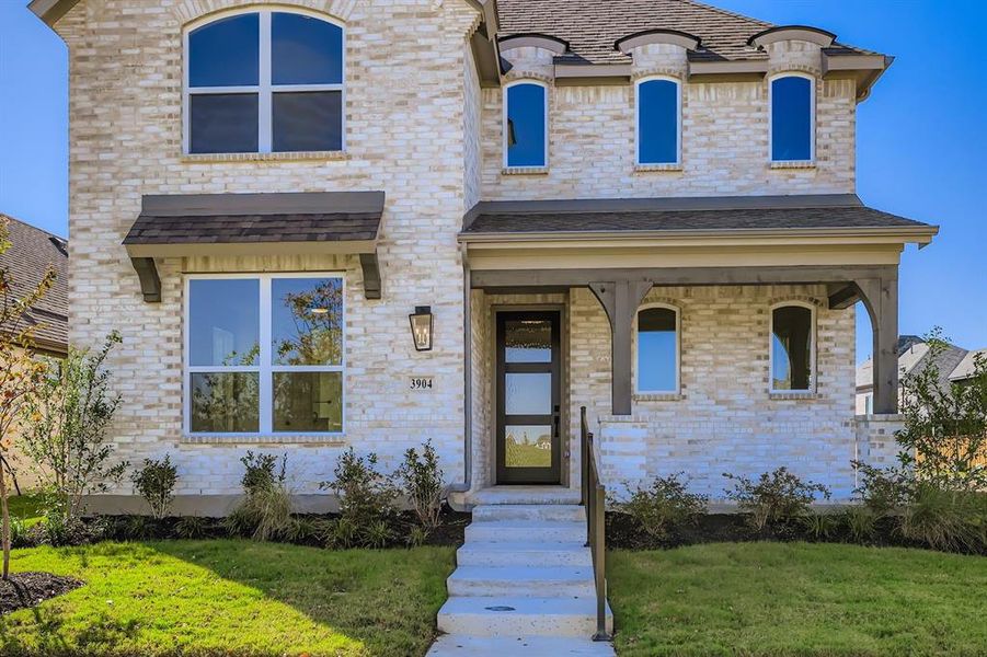 View of front of property featuring covered porch, a front yard, and brick siding View of front of property featuring covered porch, a front yard, and brick siding