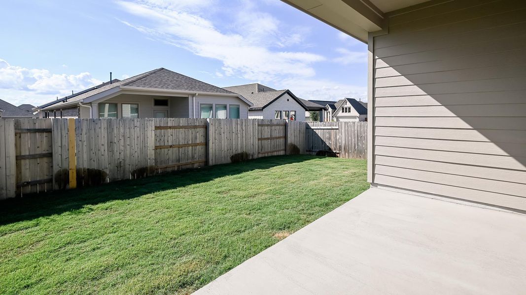 Fenced backyard featuring a patio and a residential view