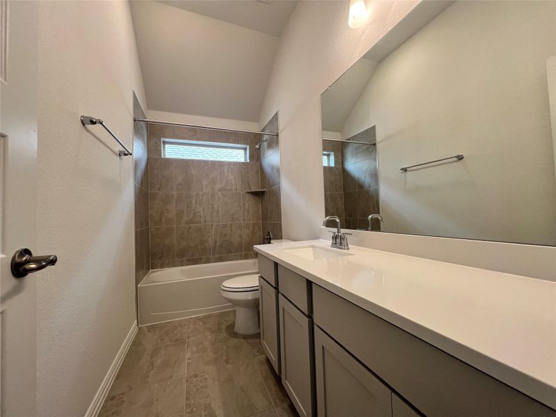 Full bathroom with vanity, bathing tub / shower combination, and lofted ceiling Full bathroom with vanity, bathing tub / shower combination, and lofted ceiling