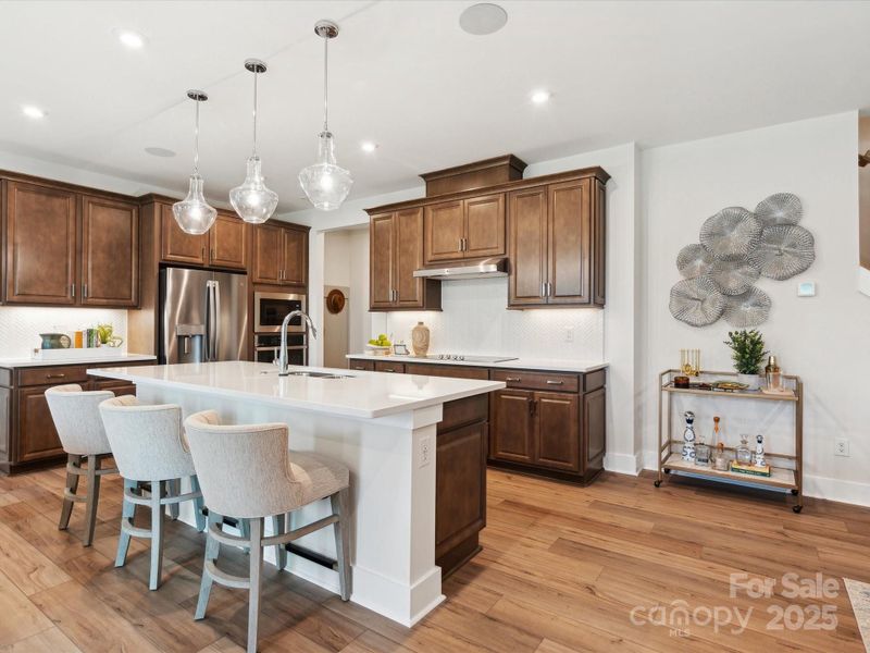Open kitchen with premium finishes. *Model Photos | Actual finishes, structural selections, and orientation may vary.