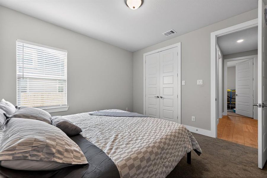 This room features neutral-toned walls, a window with blinds, and white paneled closet doors