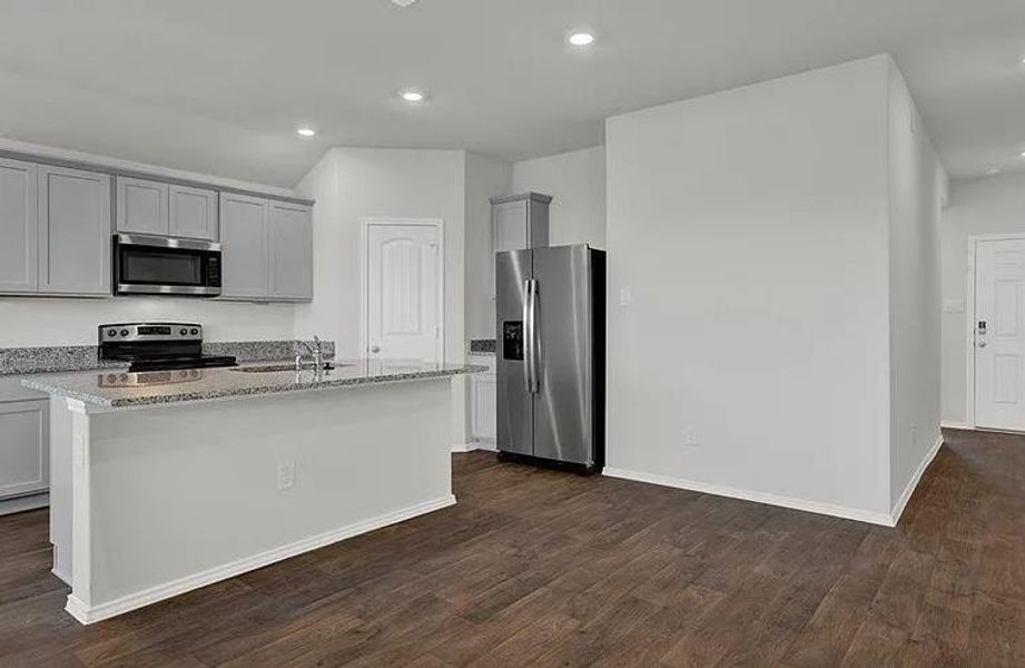 Kitchen featuring light gray cabinetry, granite countertops, stainless steel appliances, and a central island with a sink Kitchen featuring light gray cabinetry, granite countertops, stainless steel appliances, and a central island with a sink