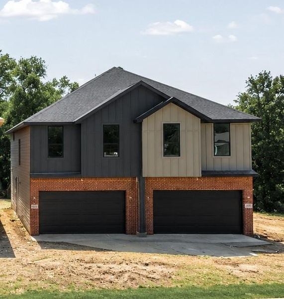 Modern duplex exterior featuring brick and vertical siding Modern duplex exterior featuring brick and vertical siding