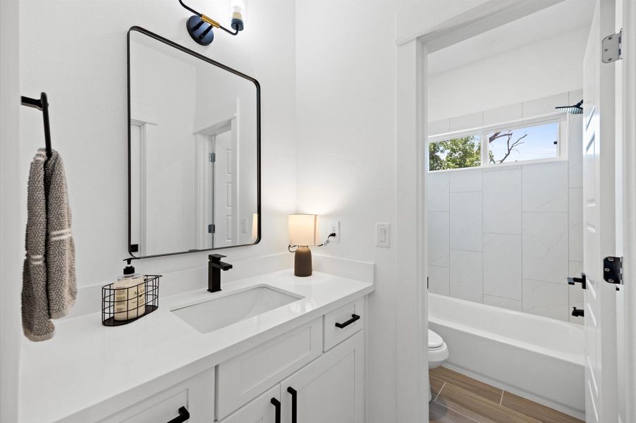 A Jack and Jill secondary bathroom designed for shared convenience, featuring a bathtub and shower combo. The space is thoughtfully laid out with dual entrances, allowing for easy access while maintaining privacy. A Jack and Jill secondary bathroom designed for shared convenience, featuring a bathtub and shower combo. The space is thoughtfully laid out with dual entrances, allowing for easy access while maintaining privacy.