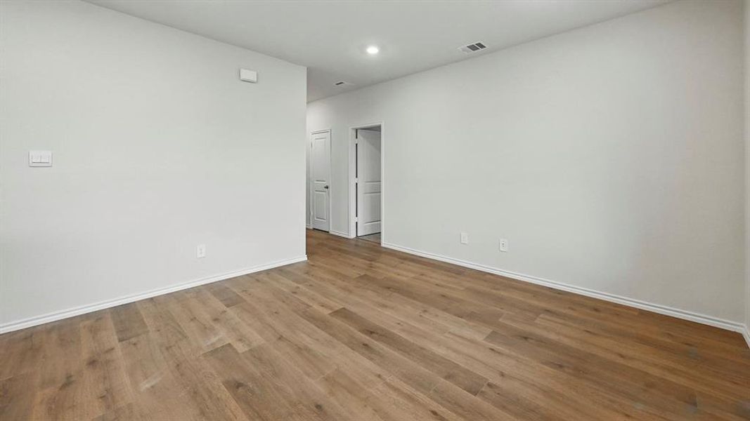 Spare room with wood finished floors and recessed lighting