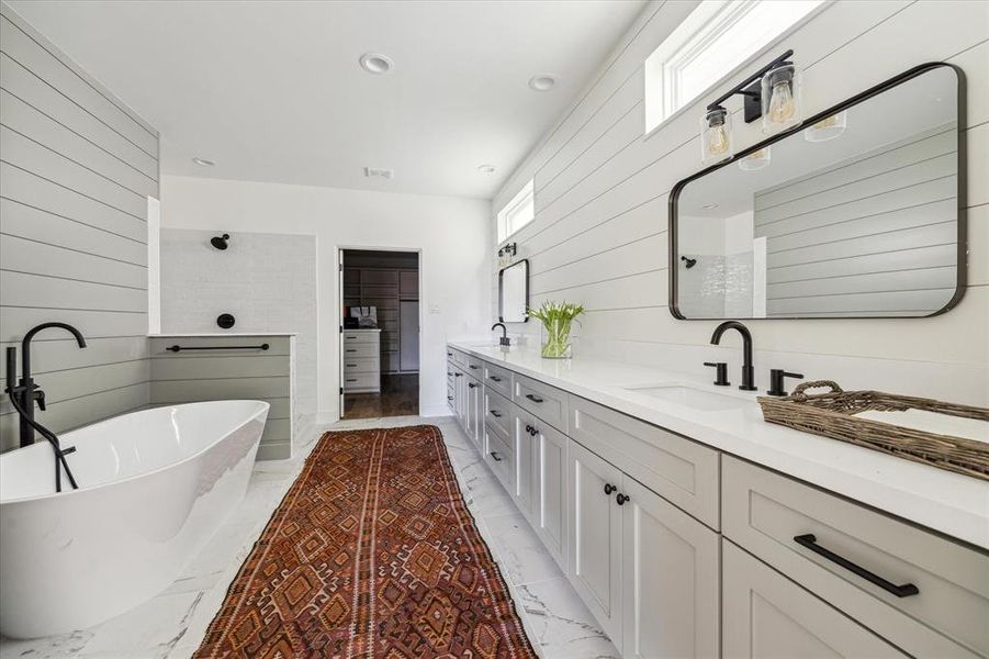 Shiplap walls painted Rain Cloud Gray add depth and design to this spacious Primary bath.