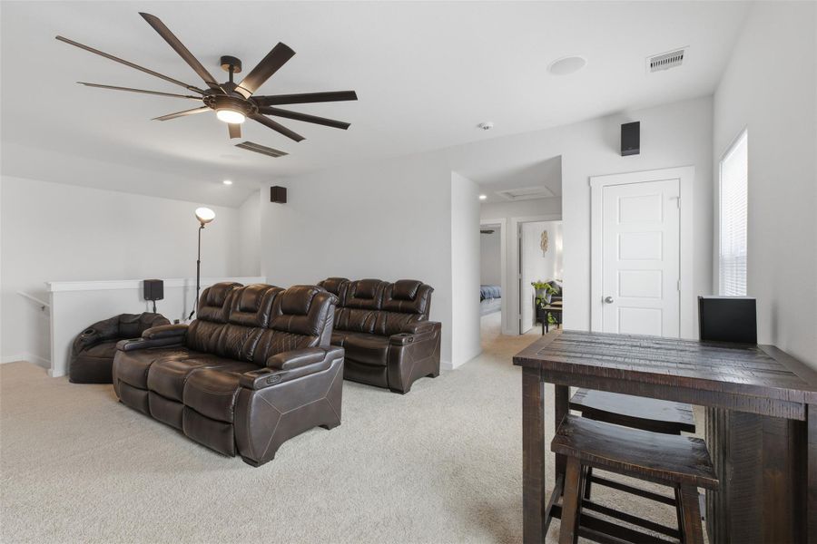 Living area featuring light carpet and ceiling fan