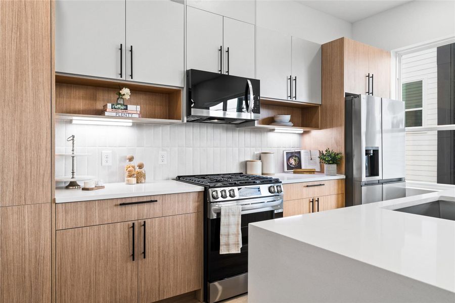 Every detail in this kitchen is designed to inspire—from the sleek gas range and built-in microwave to the wood-grain cabinetry with open shelving and soft-close drawers. The vertical tile backsplash adds subtle texture, while the oversized quartz island invites connection, creativity, and comfort in the heart of the home. Every detail in this kitchen is designed to inspire—from the sleek gas range and built-in microwave to the wood-grain cabinetry with open shelving and soft-close drawers. The vertical tile backsplash adds subtle texture, while the oversized quartz island invites connection, creativity, and comfort in the heart of the home.