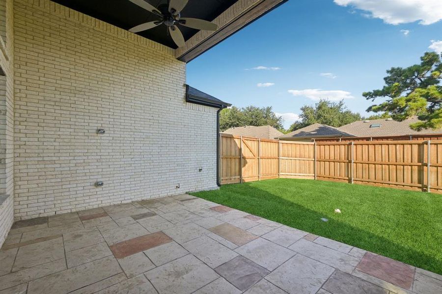 Fenced backyard with a patio area and ceiling fan