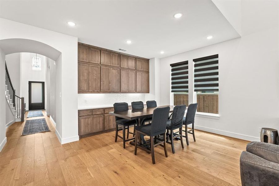 Dining area with light wood-style flooring and lots of cabinets!