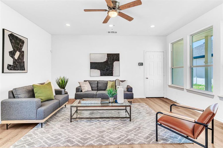 Living room with ceiling fan and light hardwood / wood-style flooring