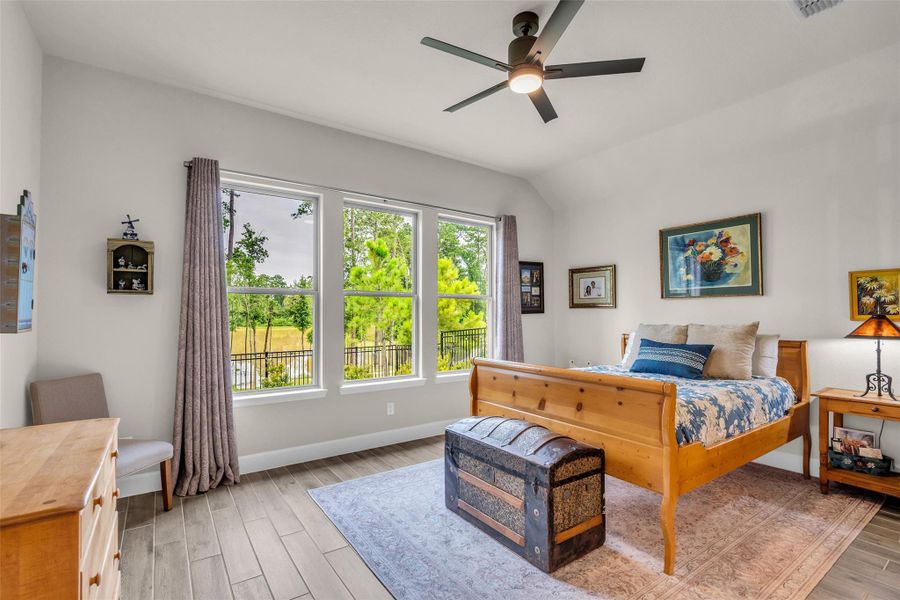The peaceful primary bedroom overlooks the backyard and provides a scenic view of the lake. The peaceful primary bedroom overlooks the backyard and provides a scenic view of the lake.