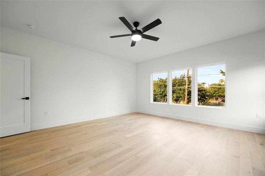 Unfurnished room with ceiling fan and light hardwood / wood-style flooring