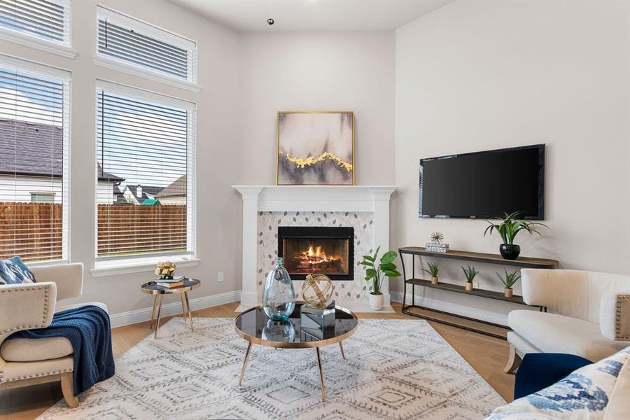 Living room featuring a healthy amount of sunlight, a tiled fireplace, and light hardwood / wood-style flooring