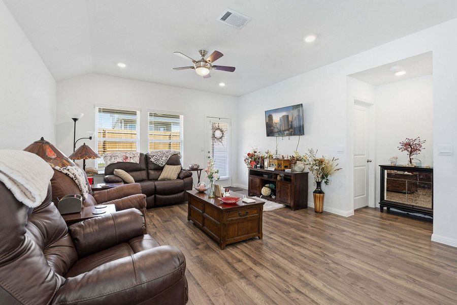Living room featuring dark wood-style floors, ceiling fan, recessed lighting, and vaulted ceiling