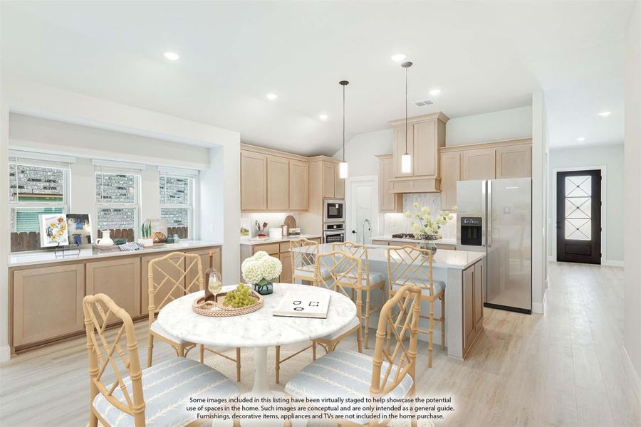 Open kitchen and dining area with light wood cabinets, center island, stainless appliances, and round dining table with rattan chairs