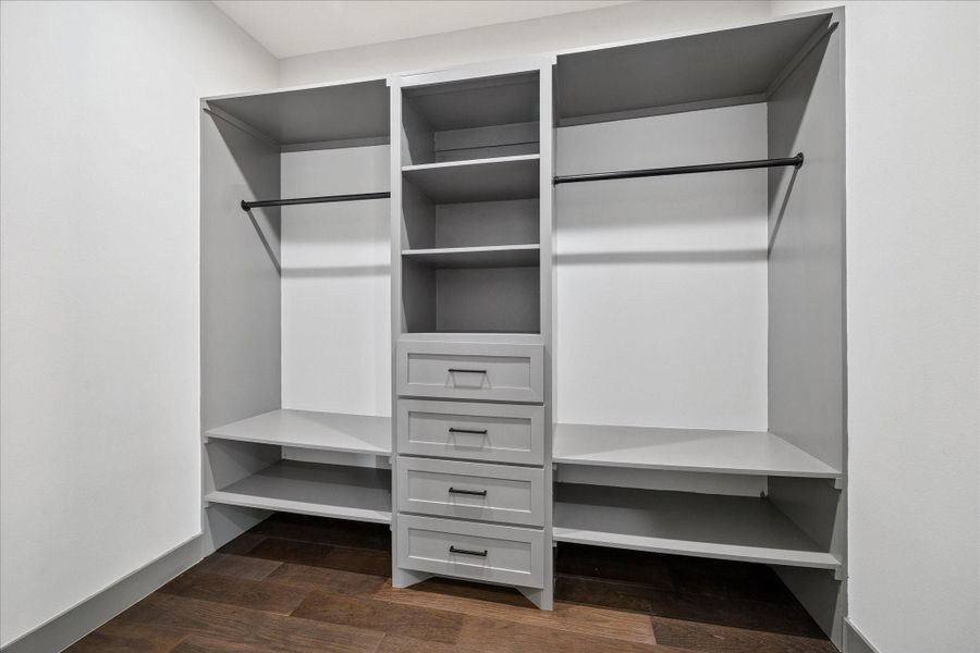 Custom built-ins with shelves, drawers, and double hanging rods maximize organization and storage. The thoughtful design provides plenty of room for clothing, shoes, and accessories, keeping everything neatly arranged.