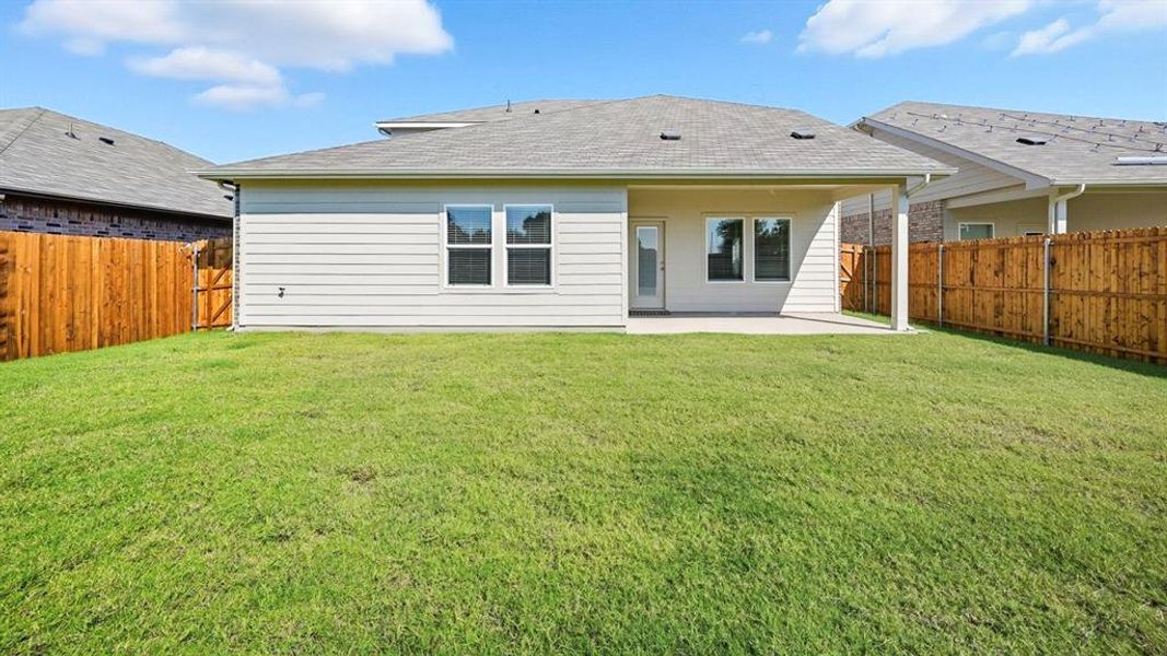 Rear view of house with a patio area, a fenced backyard, and roof with shingles