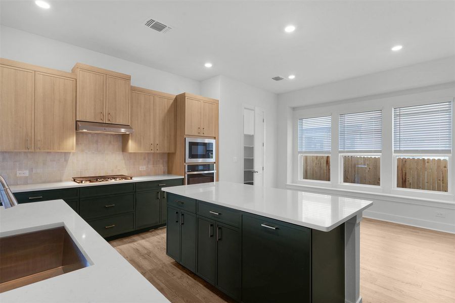 Culinary excellence awaits in this well-appointed kitchen, featuring a spacious island and gleaming countertops.
