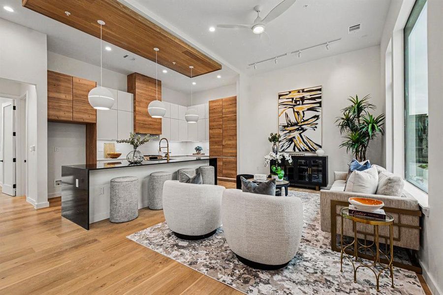 Warm modern aesthetic with two-tone cabinetry and wood wrapped ceiling.  Seamless flow between kitchen and living room with soaring ceilings and sweeping windows flooding the space with natural light.