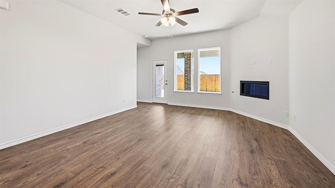 Spare room featuring dark wood-style flooring and ceiling fan