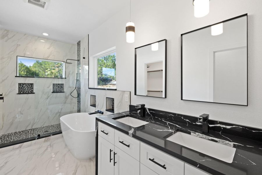 Primary Bath has double vanity with a waterfall quartz countertop.