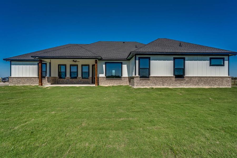 Rear view of house featuring a lawn and ceiling fan