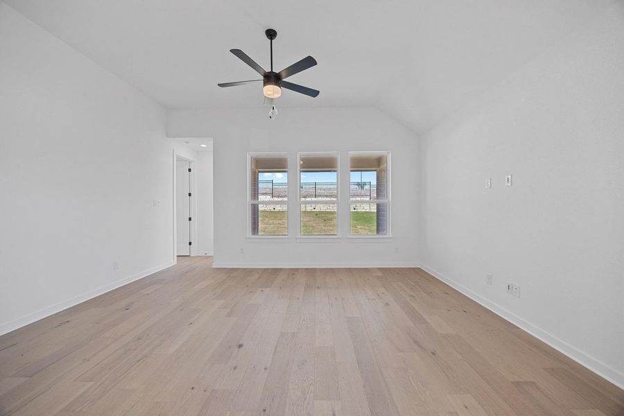 Spare room with light wood-style flooring, ceiling fan, and vaulted ceiling