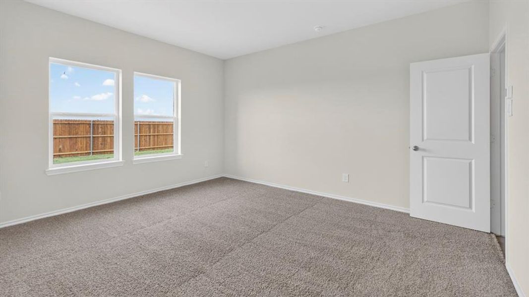 Neutral wall tones complement the gray carpeting in this spacious room