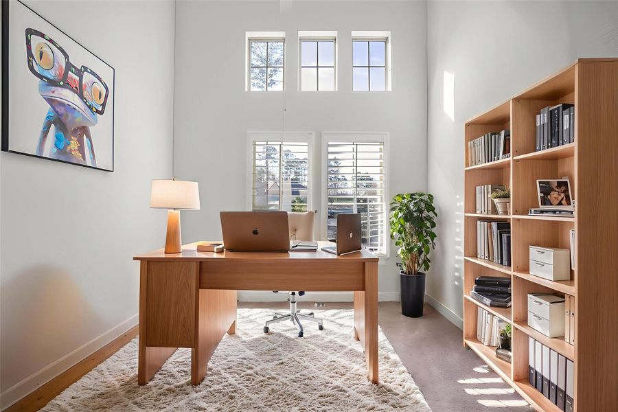 Work from home in this bright, modern home office with high ceilings and large windows. *Virtually staged*