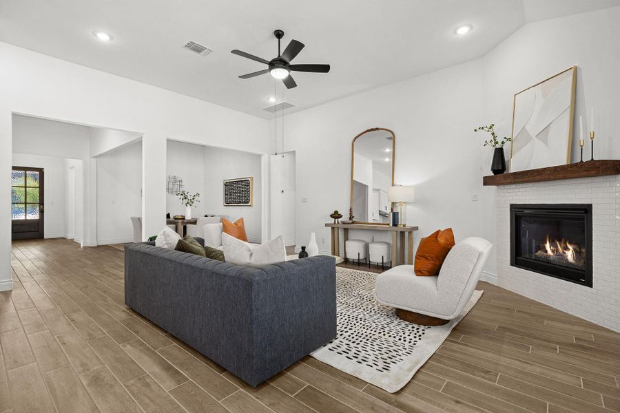 Living room with wood tiled floors, a fireplace, recessed lighting, and ceiling fan