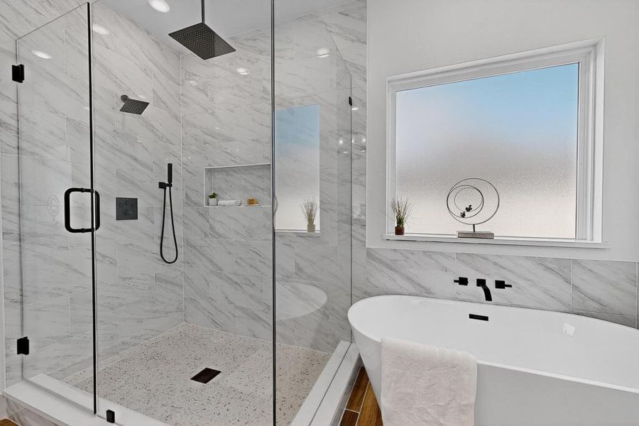Bathroom featuring a soaking tub, a marble finish shower, and tile walls
