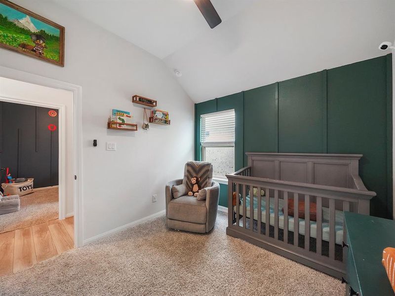 The third bedroom offers high ceilings, carpet and a gorgeous green accent wall with a new fan.