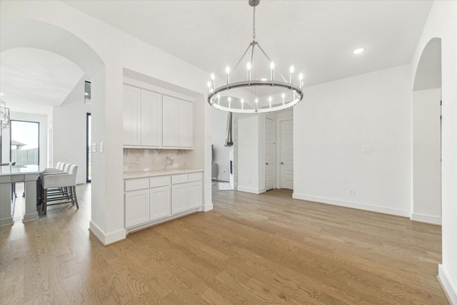 The Formal Dining room has the WOW factor and the built in butlers pantry gives you plenty of additional counter space. The crown chandelier is the focal point of the room and the continuous hardwood floors continue through this area. The Formal Dining room has the WOW factor and the built in butlers pantry gives you plenty of additional counter space. The crown chandelier is the focal point of the room and the continuous hardwood floors continue through this area.