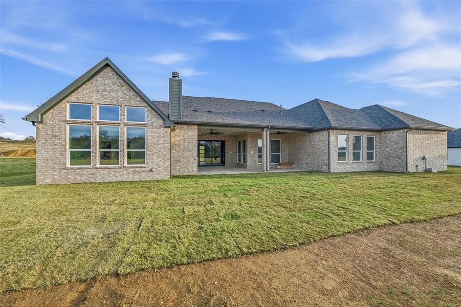 Rear view of property featuring a yard, a patio, and brick siding Rear view of property featuring a yard, a patio, and brick siding