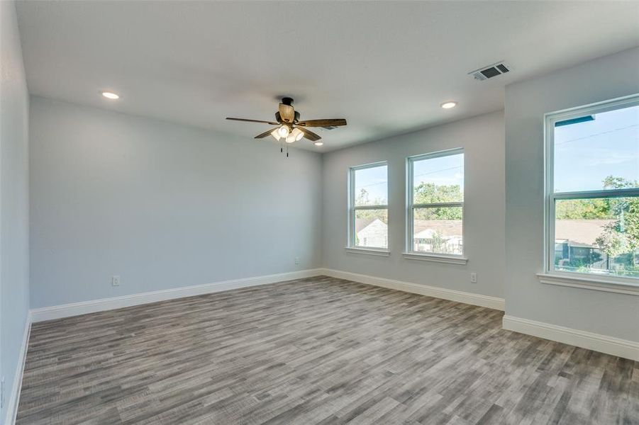 Empty room with ceiling fan and light hardwood / wood-style floors