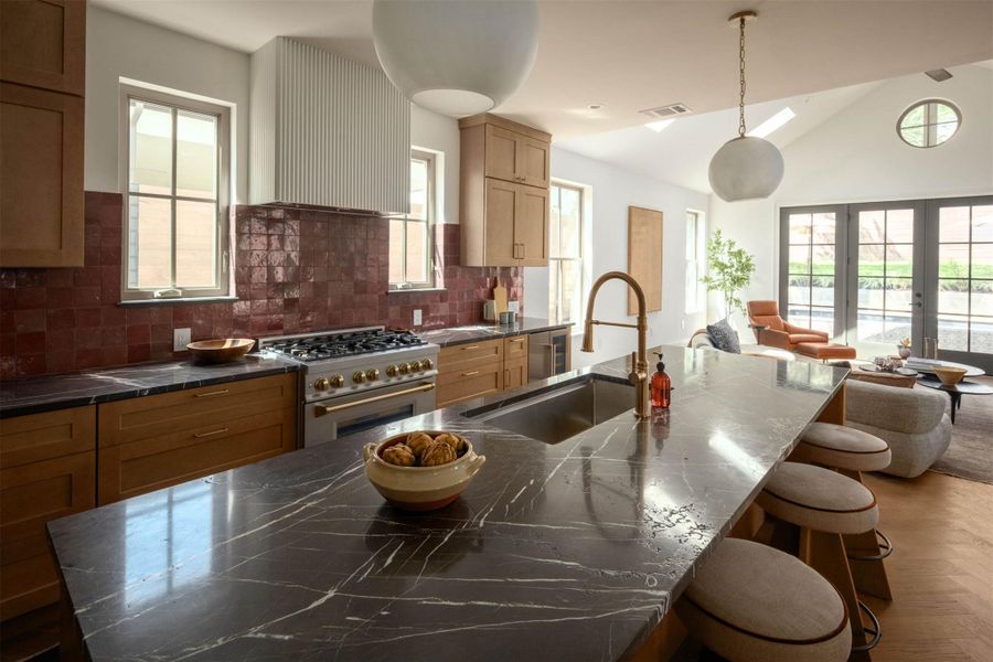 Rich wood cabinetry and veined stone countertops anchor this open gourmet kitchen space. Rich wood cabinetry and veined stone countertops anchor this open gourmet kitchen space.