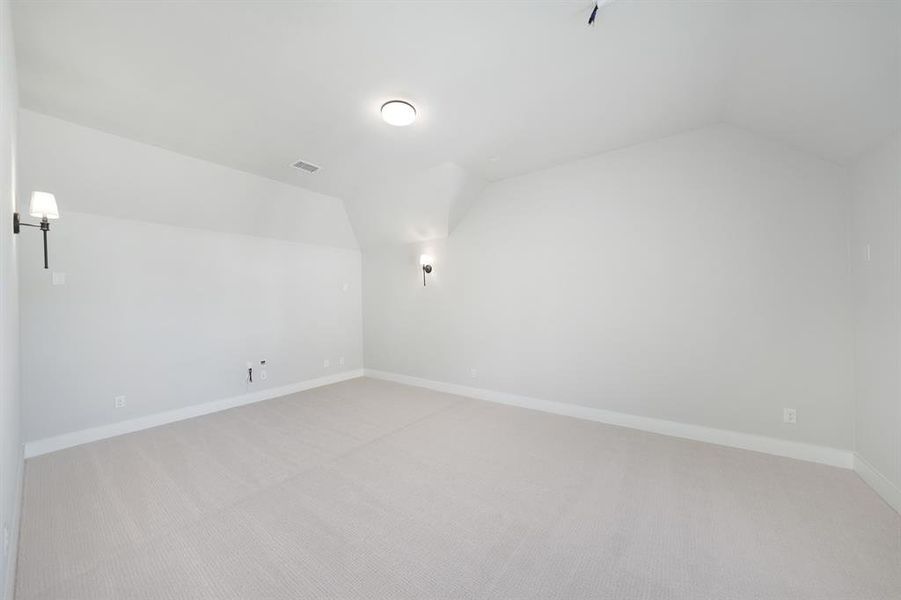 Additional living space with lofted ceiling and light colored carpet Additional living space with lofted ceiling and light colored carpet
