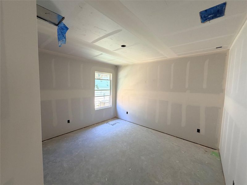 A well-lit bedroom space, awaiting finishing touches.