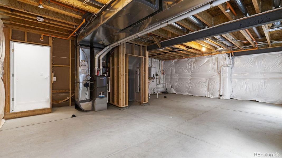 Unfinished basement with rough-in bathroom plumbing.