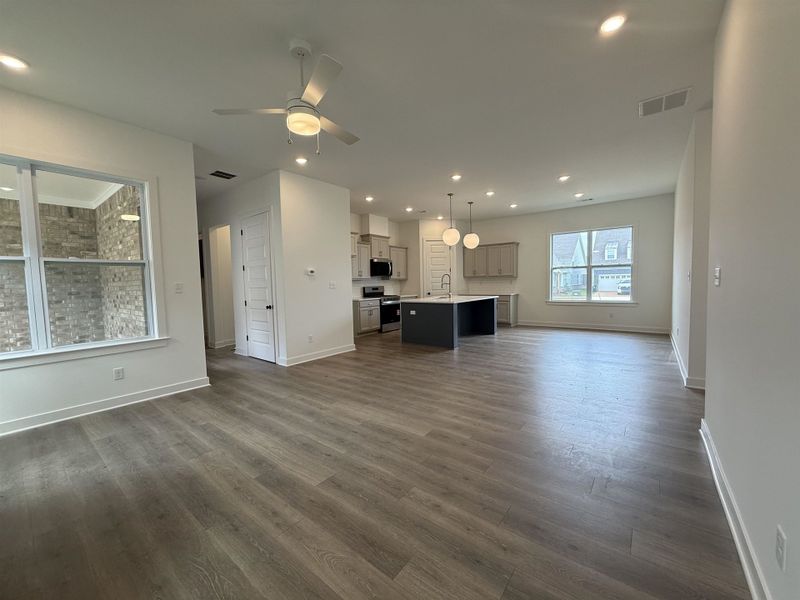 Open-concept living area with wood-finish flooring, recessed lighting, and a modern ceiling fan