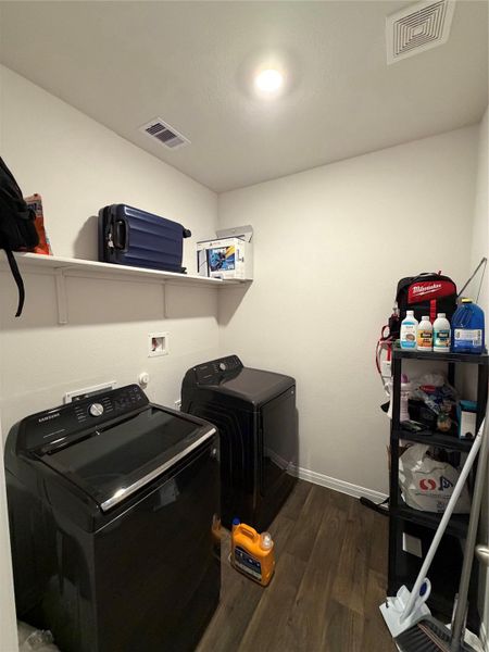 Laundry room featuring dark wood-style floors and washing machine and dryer