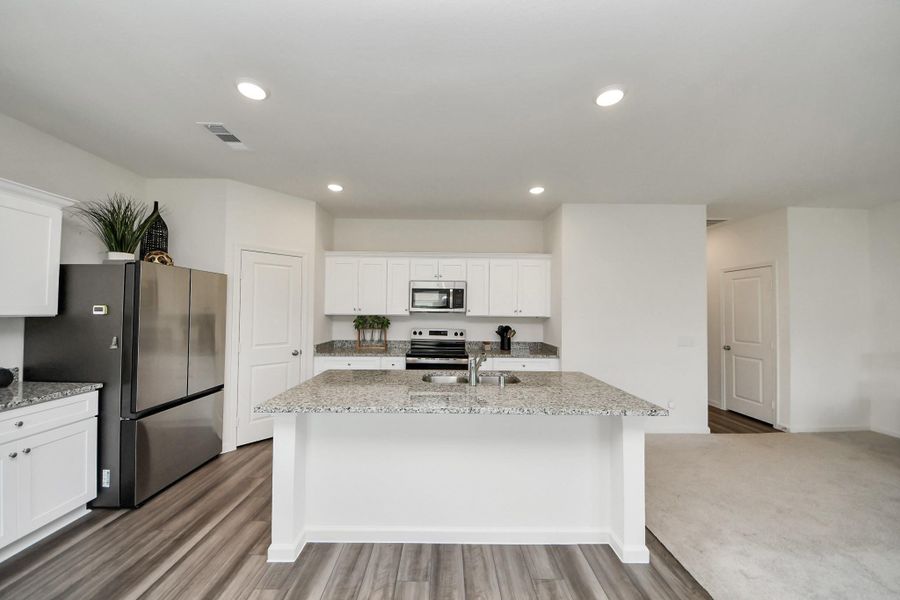 Bright and modern kitchen featuring granite countertops, stainless steel appliances, and ample cabinetry, offering a perfect blend of style and functionality.