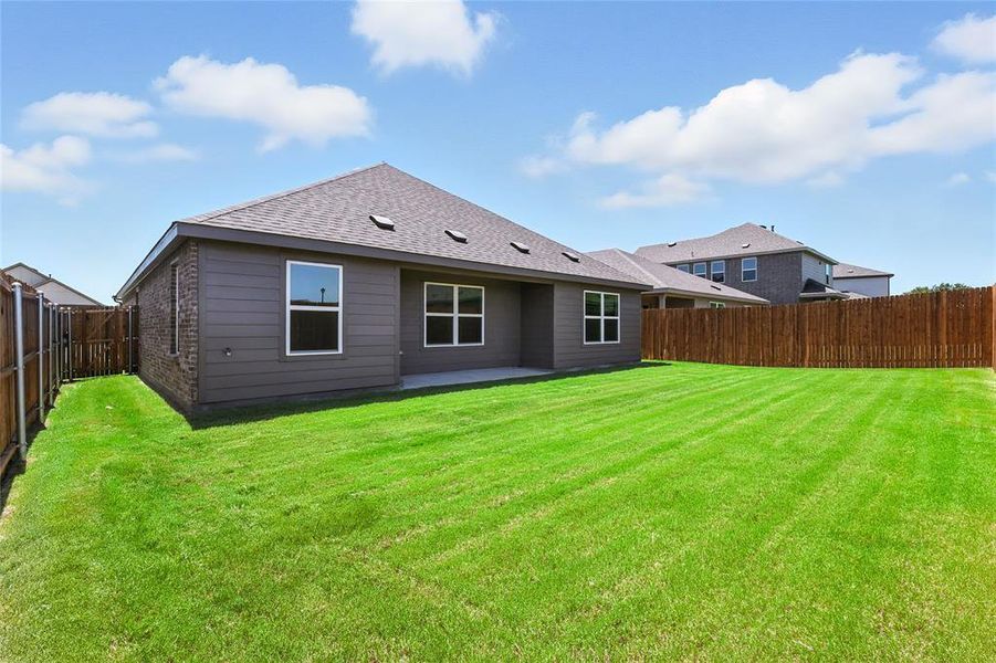 Back of property with a patio area, a fenced backyard, a shingled roof, and brick siding
