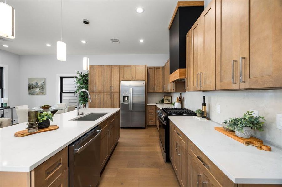 Stunning gourmet kitchen featuring sleek quartz countertops, incredible storage, and high-end stainless steel appliances.