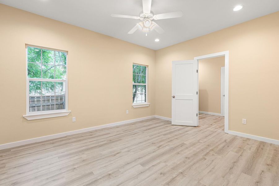 Empty room with light wood-style floors, plenty of natural light, a ceiling fan, and recessed lighting