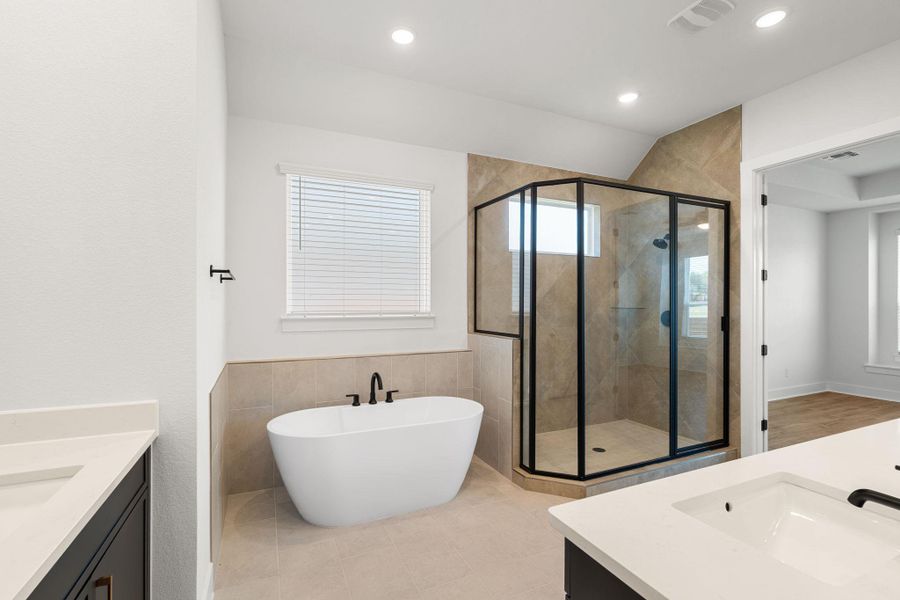 Luxurious bathroom features a spacious soaking tub and a sleek, modern glass-enclosed shower.