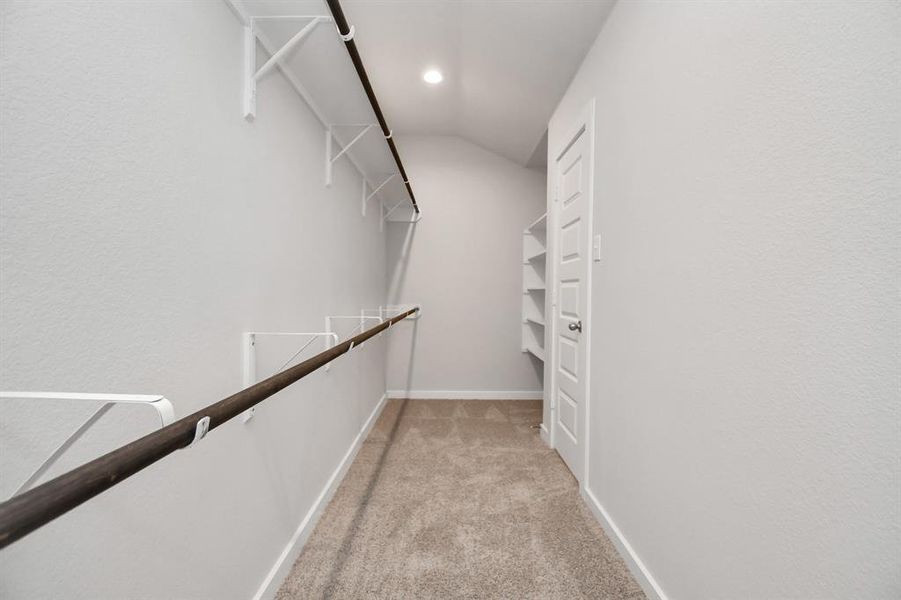 This generously sized walk in closet space boasts built-in shelving, providing ample room for organization.